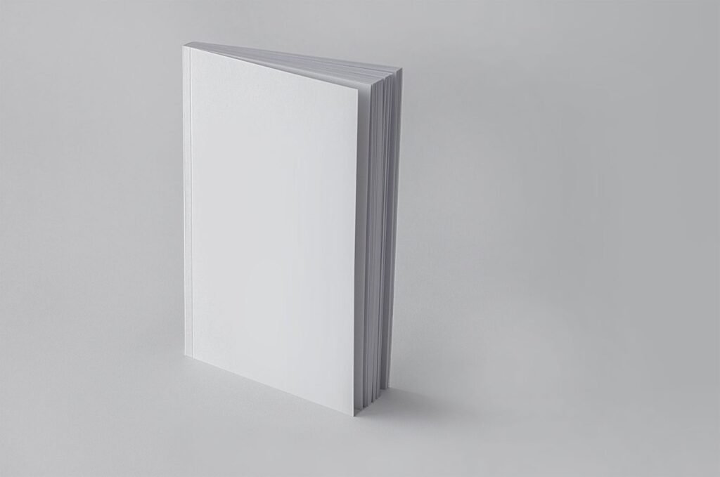 Plain white notebook standing upright against a grey background