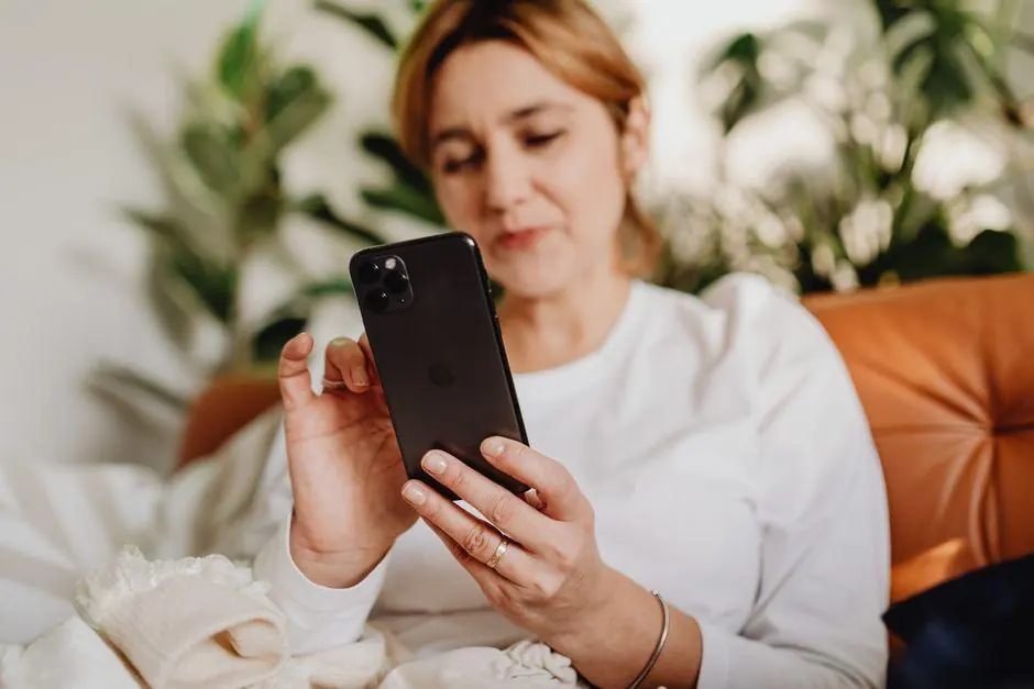 Woman sitting on a sofa looking at her smartphone