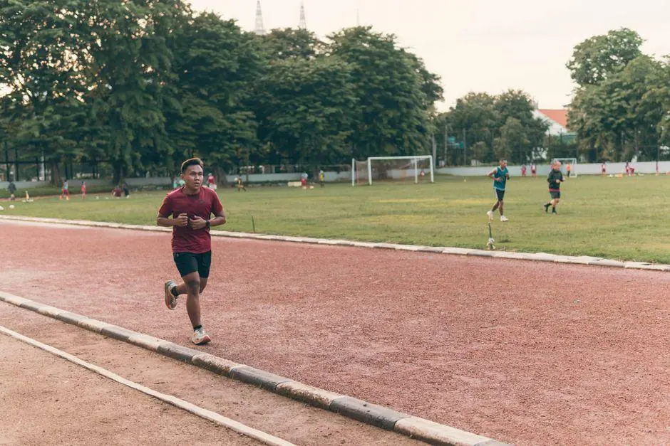 Runner on an outdoor track beside a grassy field