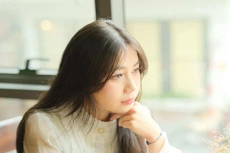 Young woman looking thoughtfully out of a window