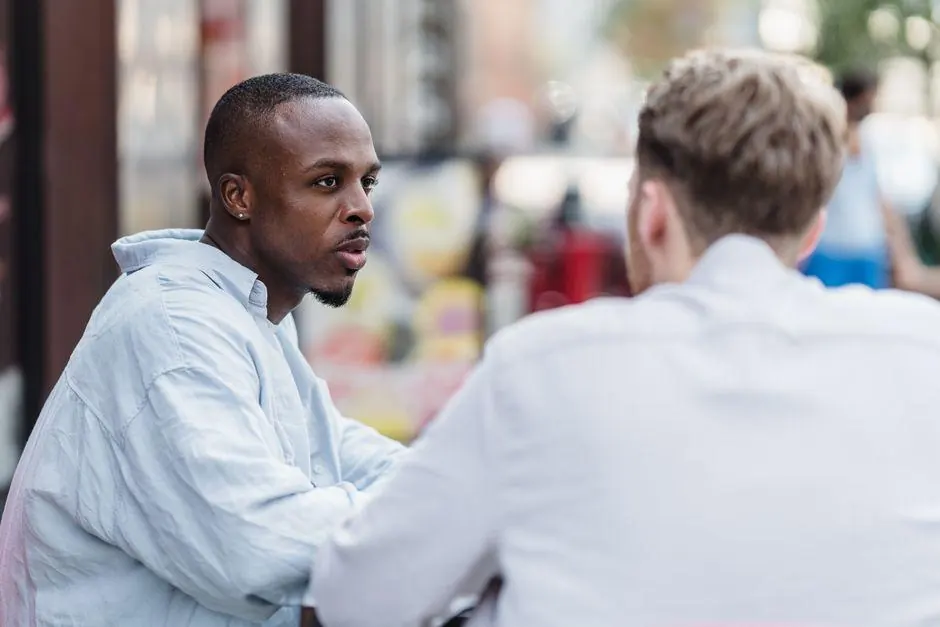 Two men talking at an outdoor table