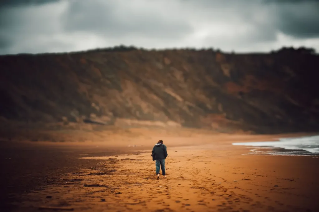 Person walking alone along a sandy beach