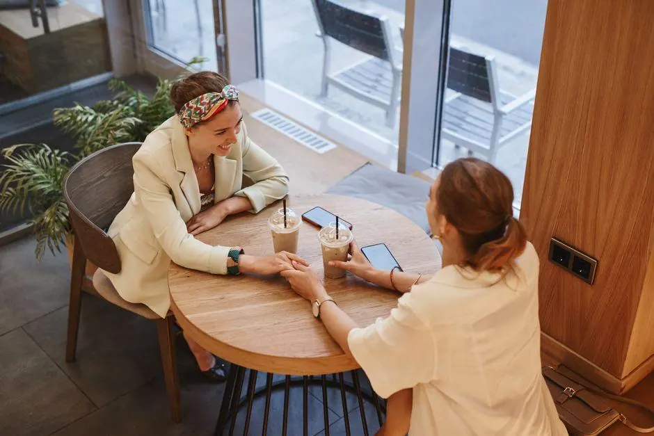 Two women talking across a cafe table