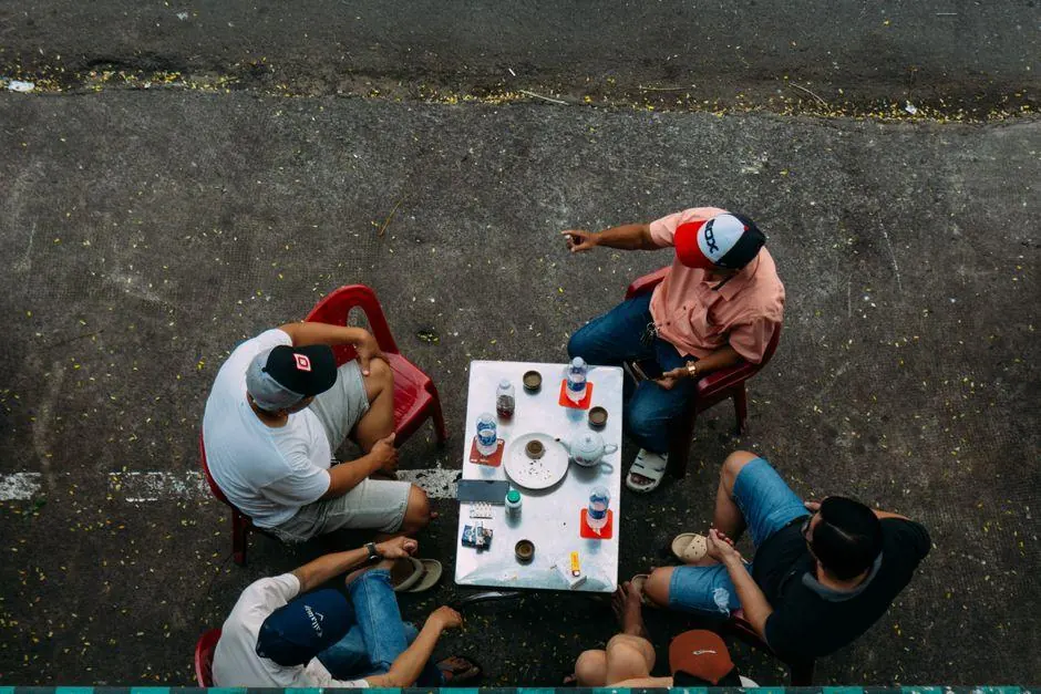 Four people sitting around an outdoor cafe table