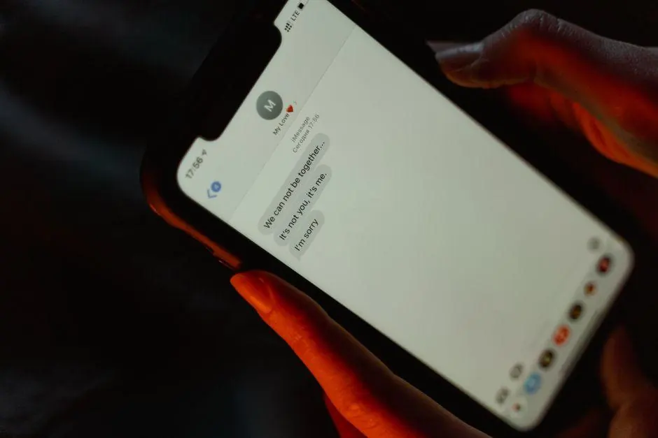 Hand holding a smartphone with a message conversation open