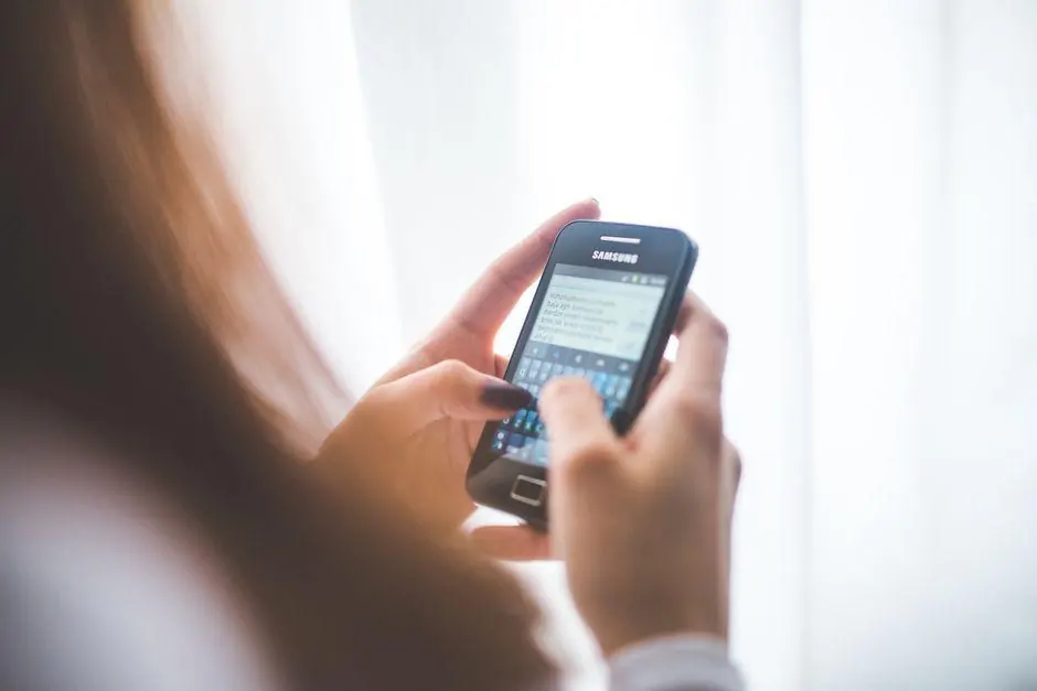 Person typing a message on a mobile phone