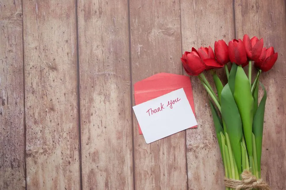 Thank-you card and red tulips on wooden boards