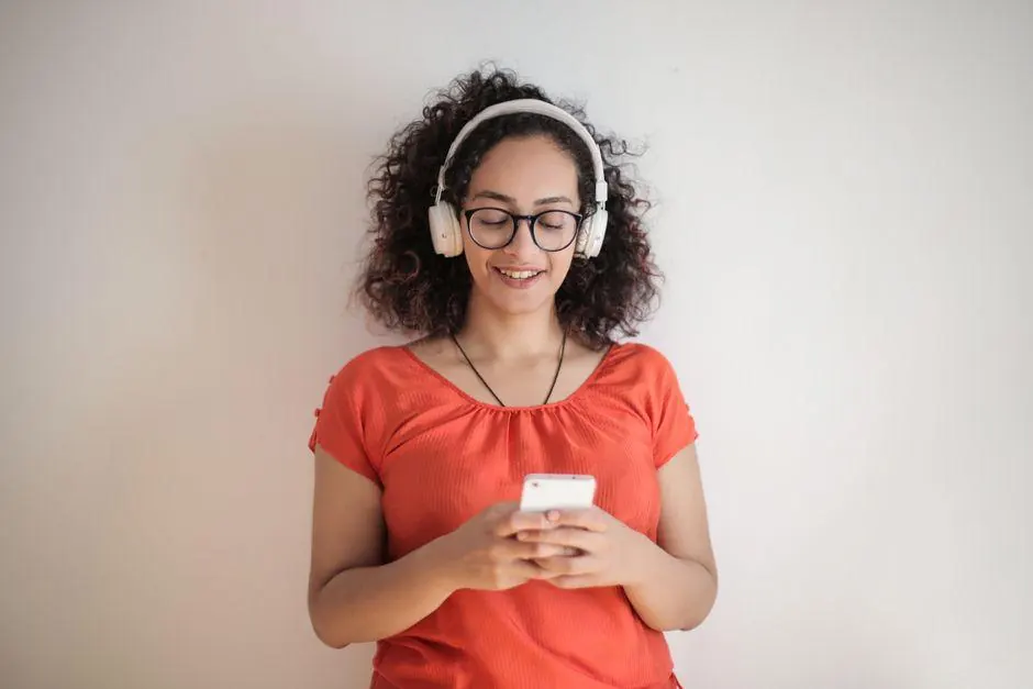 Woman wearing headphones while looking at a smartphone