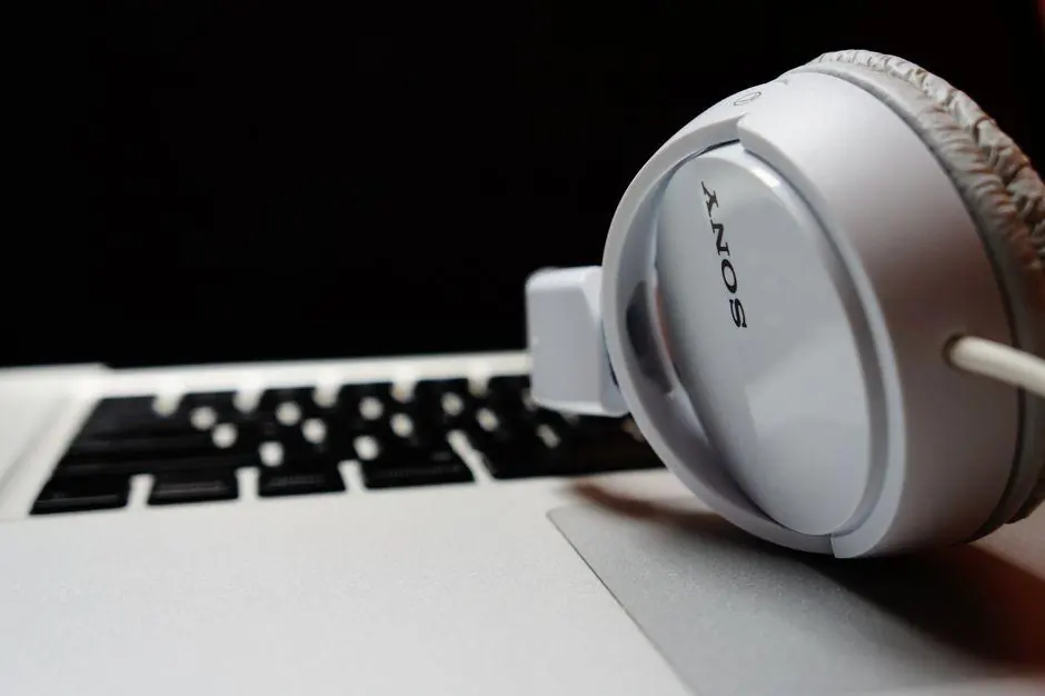 White headphones resting on a laptop keyboard