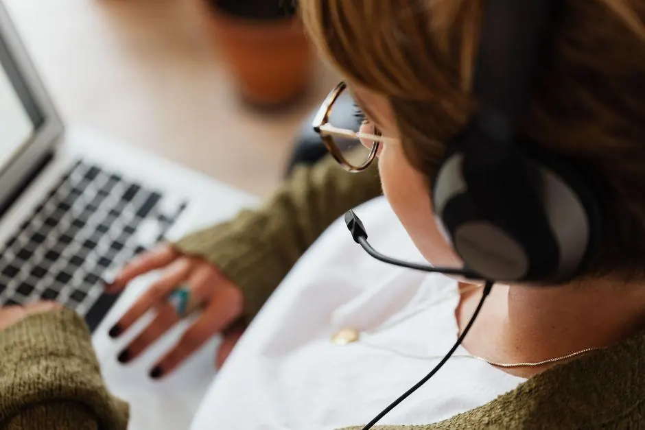Person wearing a headset while using a laptop