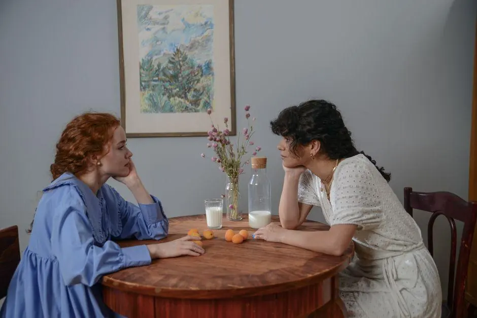 Two women talking thoughtfully at a kitchen table